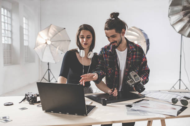 istock Female Photographer and assistant preparing photo shoot in studio 1143602765
