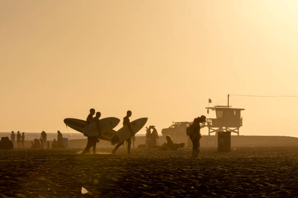 grande grupo de pessoas andando na praia de veneza e surfboards carreg, santa monica, califórnia - venice califórnia - fotografias e filmes do acervo