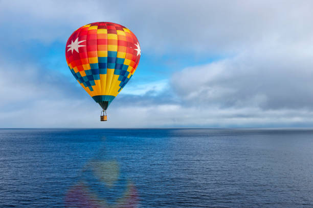 istock Hot air balloon over calm ocean 1143607505