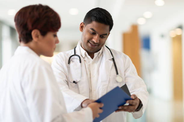istock Doctors review treatment plan in hospital corridor 1143612679