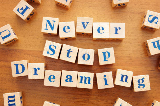 istock Never stop dreaming. Conceptual image with the text made from wooden cubes on a desk 1143615613