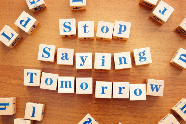 istock Stop saying tomorrow. Conceptual image with the text made from wooden cubes on a desk 1143615655