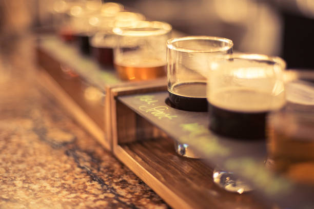 Macro beer flight on bar counter Closeup of beer flight sampler in perspective view microbrewery stock pictures, royalty-free photos & images