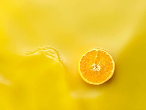 istock Single orange slice on Orange Juice background from above 1143624159
