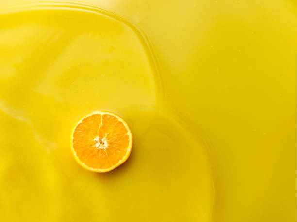 istock Single orange slice on Orange Juice background from above 1143624166