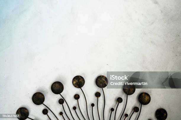Uniquedesigned Metal Homedecor Item On White Rough Concrete Wall Stock Photo - Download Image Now