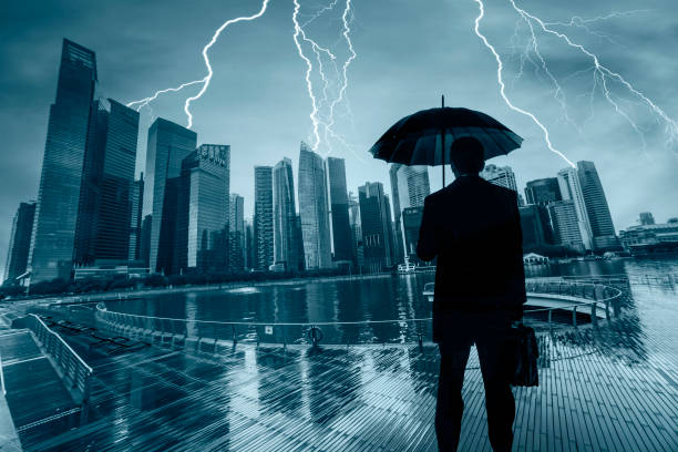 geschäftsmann mit umbrella schaut sturm über stadt - lightning thunderstorm city storm stock-fotos und bilder
