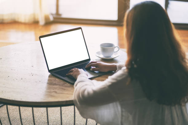 istock a woman using and typing on laptop with blank white desktop screen on the table while sitting on the floor 1143629472