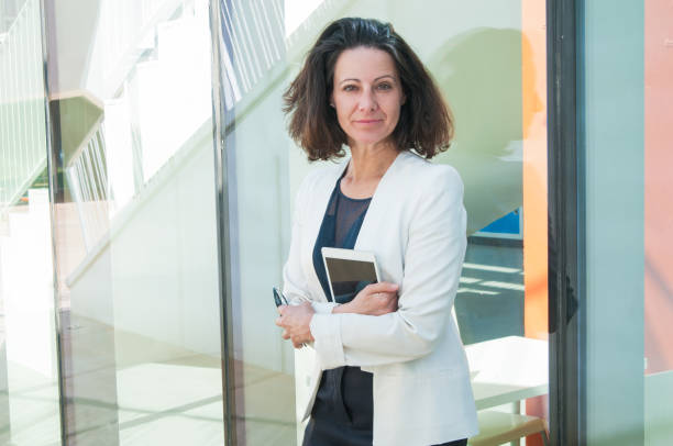 istock Serious woman holding phone and tablet in hands 1143629648