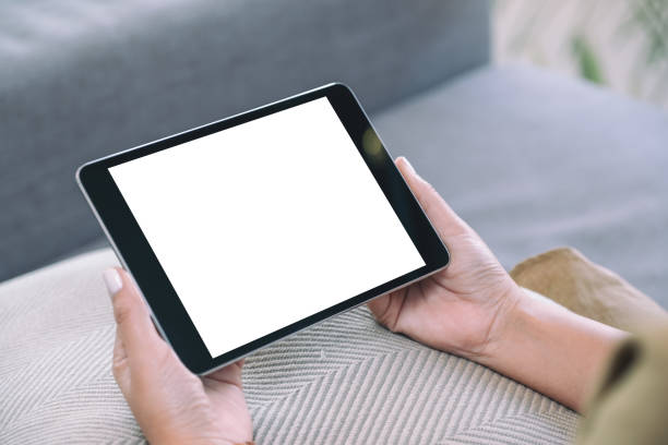 istock a woman holding black tablet pc with blank white desktop screen while sitting in living room 1143630621