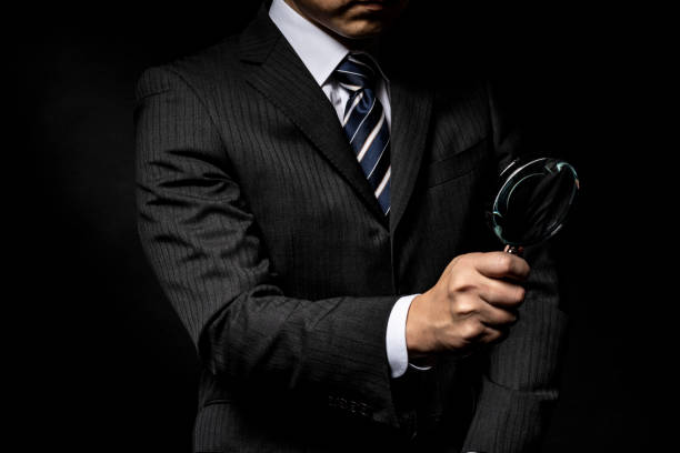istock Man in a suit with a magnifying glass in his hand 1143631705
