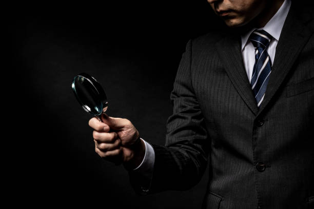 istock Man in a suit with a magnifying glass in his hand 1143631708