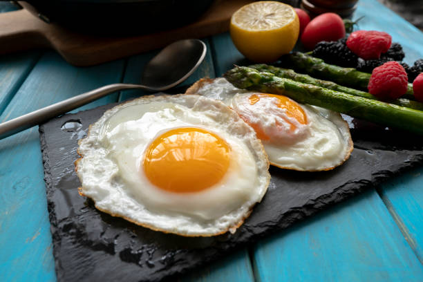 istock fried eggs, vegetables and fruits on breakfast table 1143633485