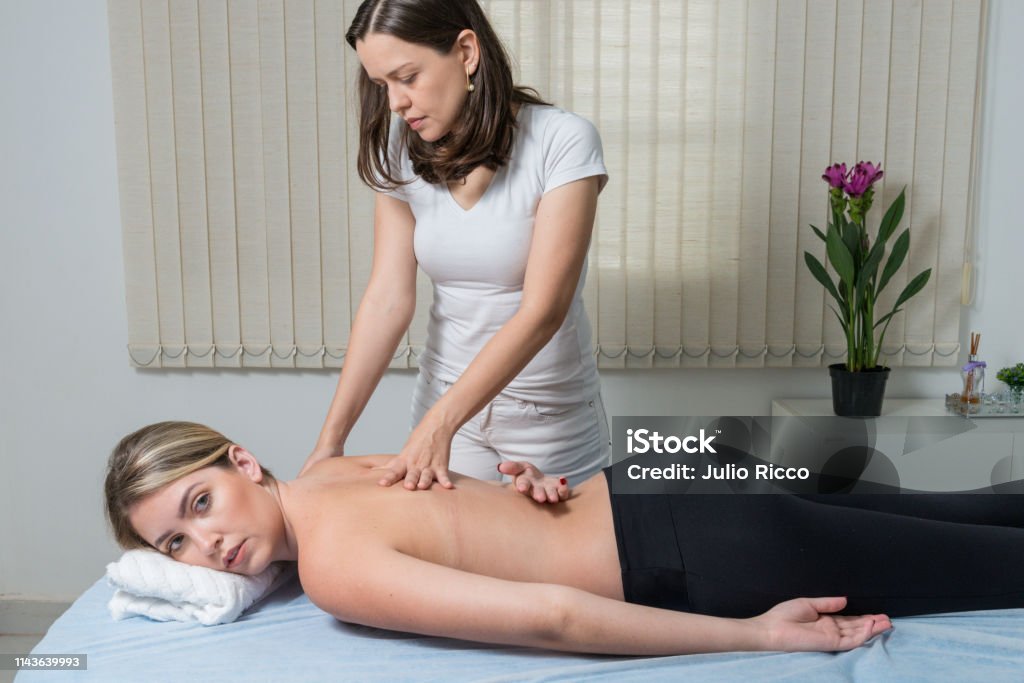 Beautiful blond woman receiving Shiatsu Treatment from a therapist Beautiful blond woman receiving Shiatsu Treatment from a therapist. Adult Stock Photo