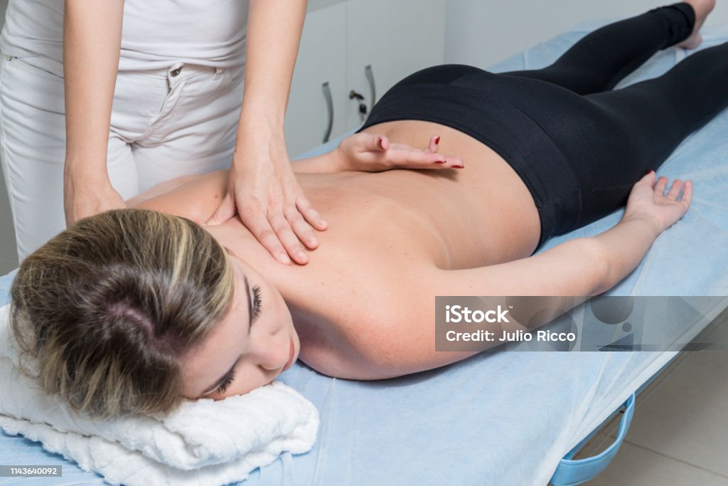 Beautiful blond woman receiving Shiatsu Treatment from a therapist Beautiful blond woman receiving Shiatsu Treatment from a therapist. Adult Stock Photo