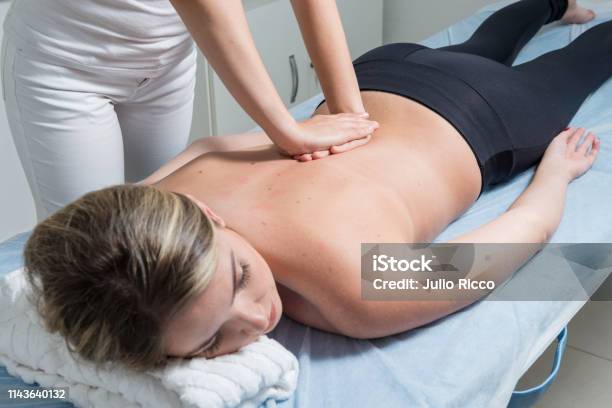 Beautiful Blond Woman Receiving Shiatsu Treatment From A Therapist Stock Photo - Download Image Now