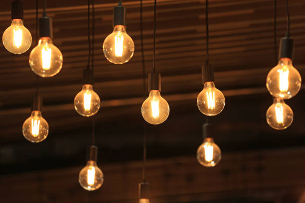 istock Vintage glowing light bulbs hanging. Decorative antique style light bulbs. 1143640155