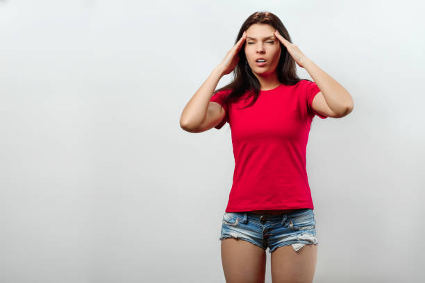 istock A young, beautiful girl puts her hands to her temples. Isolated on a light background. Different human emotions, feelings of facial expression, attitude, perception, body language, reaction. 1143640506