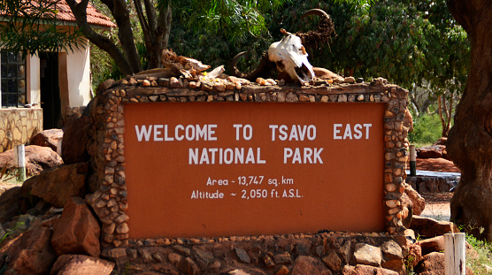 Sign welcomes visitors in Tsavo West National Park in Kenya