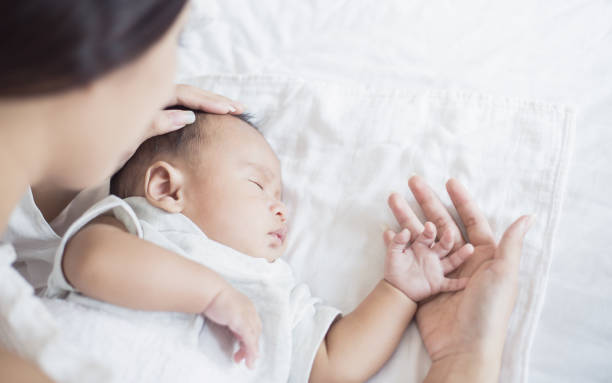 母親は病気の赤ちゃんの体温をチェックし、新生児は熱を持っていました。ヘルスケア医療 motherâs デイコンセプト - chinese doctor ストックフォトと画像