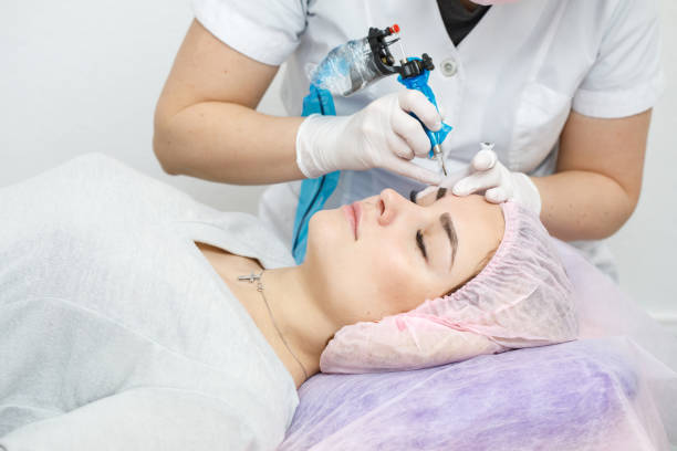 istock Permanent makeup, tattooing of eyebrows. Cosmetologist applying make up 1143645192
