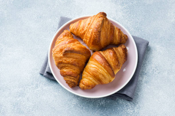 istock Breakfast croissants on a plate and a Cup of coffee on the table, copy space. 1143647507