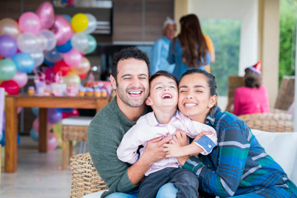 Couple and their latin child of different ages are at a birthday celebration