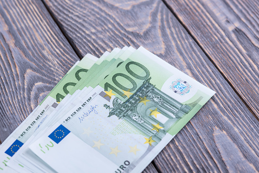 Euro cash banknotes on a dark wooden background