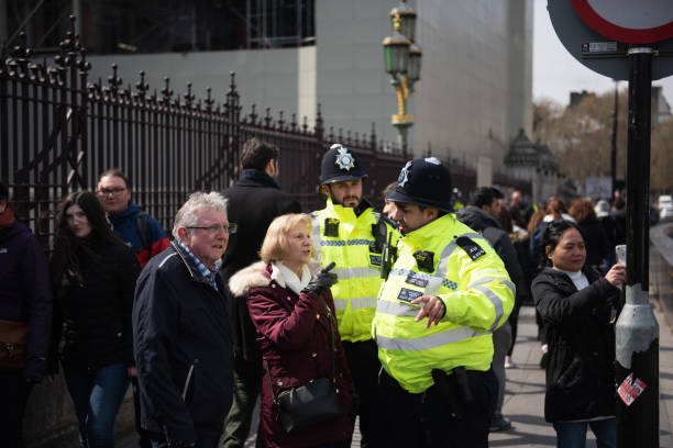 London, United Kingdom, April 13th 2019:- Two police officers helping people outside Westminster Parliament. stock photo