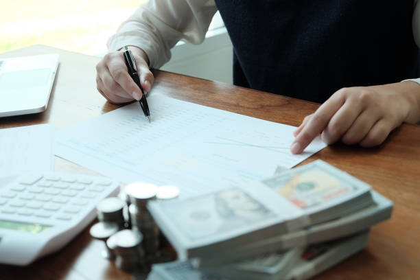 istock Businessman analyzing investment charts and pressing calculator buttons over documents. Accounting Concept  Saving Economy concept. 1143655111