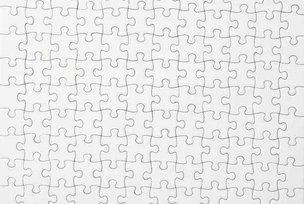 Close-up and overhead shot of blank white jigsaw puzzle texture background.