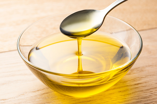 Scoop olive oil with a spoon