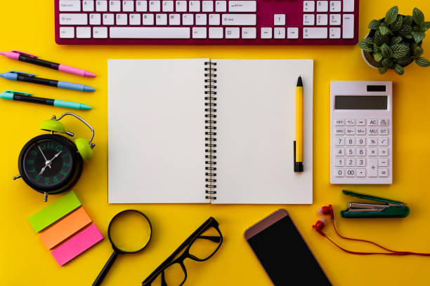 istock Blank white notepad with office and personal accessories isolated on yellow background. 1143661940