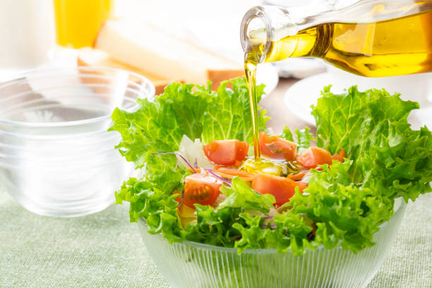 apply olive oil to the salad - morning tomato lettuce vegetable imagens e fotografias de stock