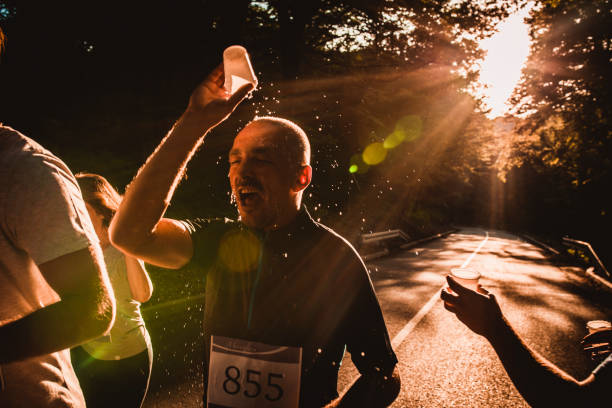 istock Athletic man refreshing himself while participating in marathon race at sunset. 1143665190