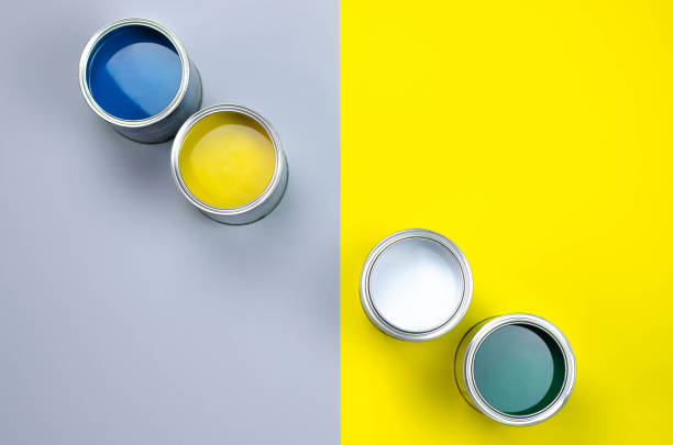 istock Four open cans of paint on a gray-yellow background. 1143667292