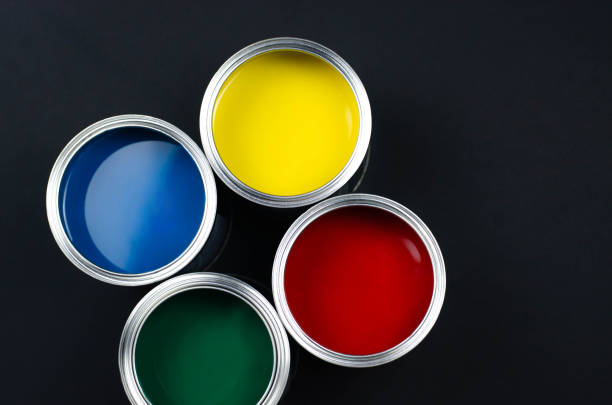 istock Four open cans of paint on a black background. 1143667334
