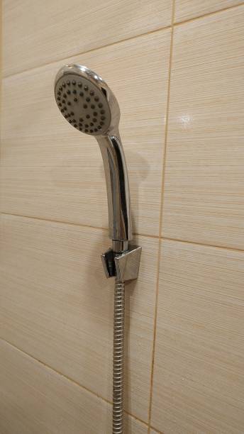 istock The shower watering can fixed in a wall arm. Close-up. 1143671965