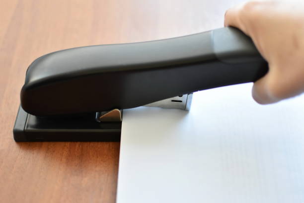 istock Hand holding paper stapler with paper 1143680765