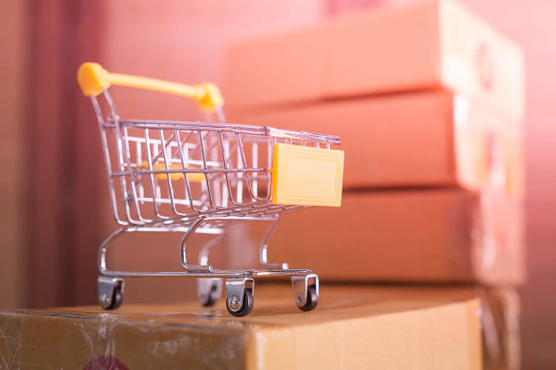 istock mini yellow shopping cart with cardboard boxes in background 1143681128