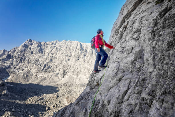 istock Bold - Alone Rock Climber on the way to summit - Watzmann in background 1143685331