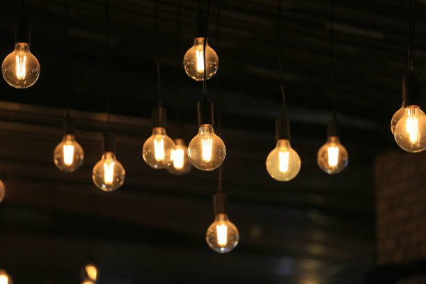istock Vintage glowing light bulbs hanging. Decorative antique style light bulbs. 1143685450
