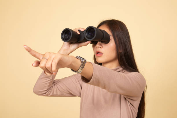 istock Young Asian woman  point and look with binoculars. 1143688705
