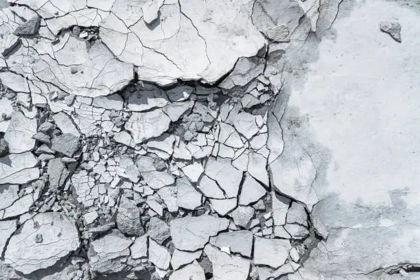 Photo of Grey pattern or textured background with cracked concrete.