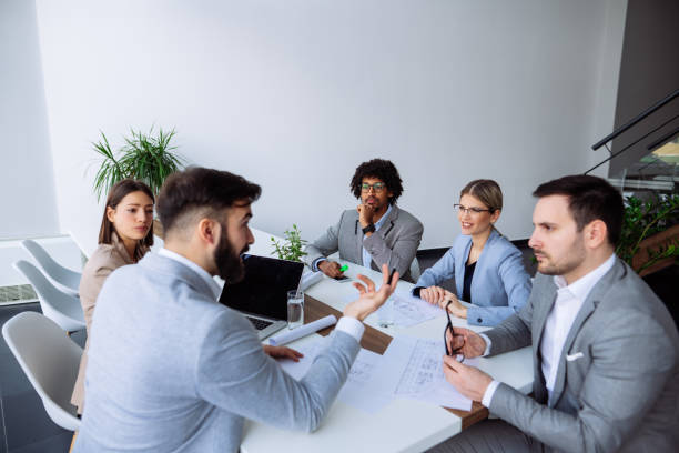 istock Multi ethnic group of architects working on plans in board room 1143690195