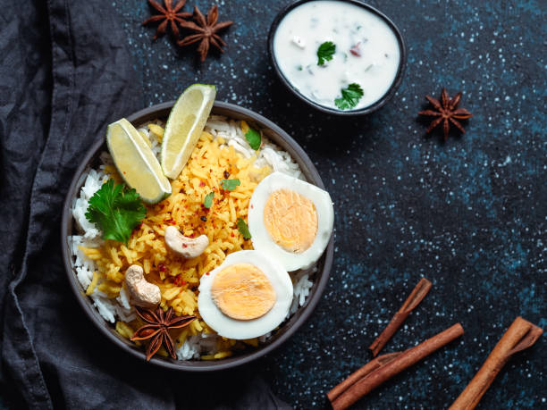 Indian Egg Biryani or anda rice, copy space Indian Egg Biryani or anda rice top view on dark background. Egg Biryani - Basmati rice cooked with masala roasted eggs and spices, served with yogurt. Copy space for text hyderabad pakistan stock pictures, royalty-free photos & images