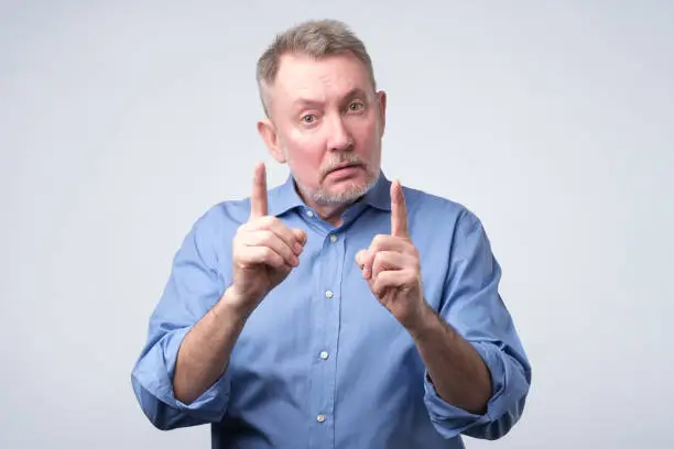 Photo of Man showing index fingers up, giving advice