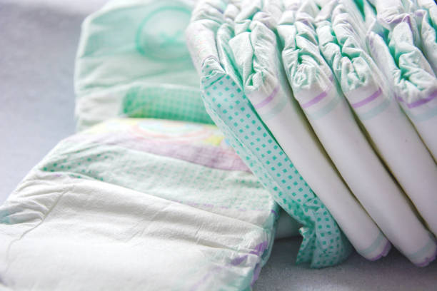 istock Group of disposable diapers arranged over a white changing table 1143696007