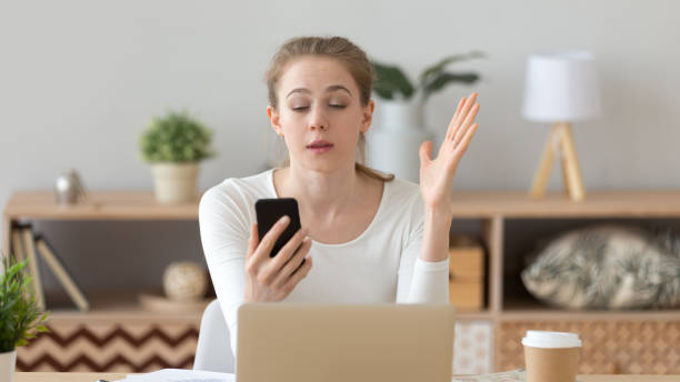 istock Irritated young woman using phone at workplace, reading bad news 1143696564