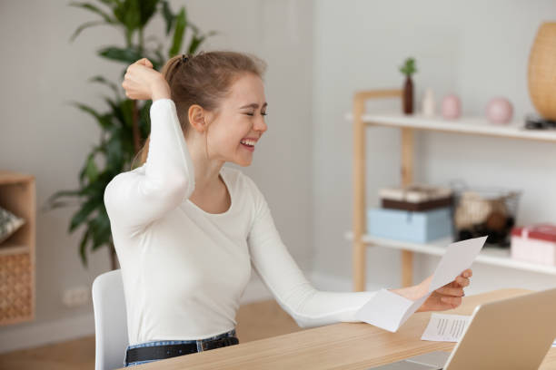 Happy young woman reading good news in paper letter, notification Happy young woman reading good news in paper letter, excited female student or employee receiving positive notification, successful exam results, deal, celebrating success or opportunity, new job college acceptance letter stock pictures, royalty-free photos & images